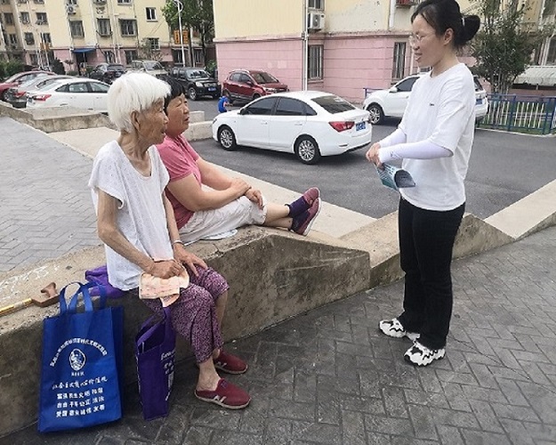 實踐隊員在長樂小區(qū)與老人采訪宣傳