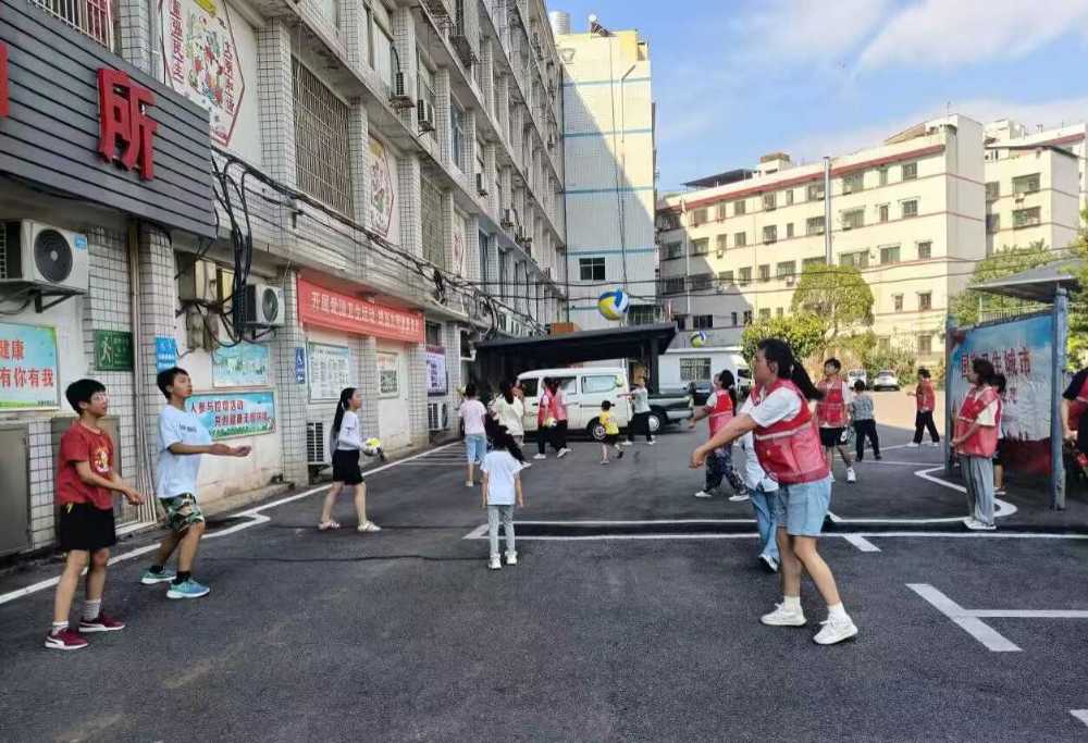 圖為志愿者與小朋友一起打氣排球